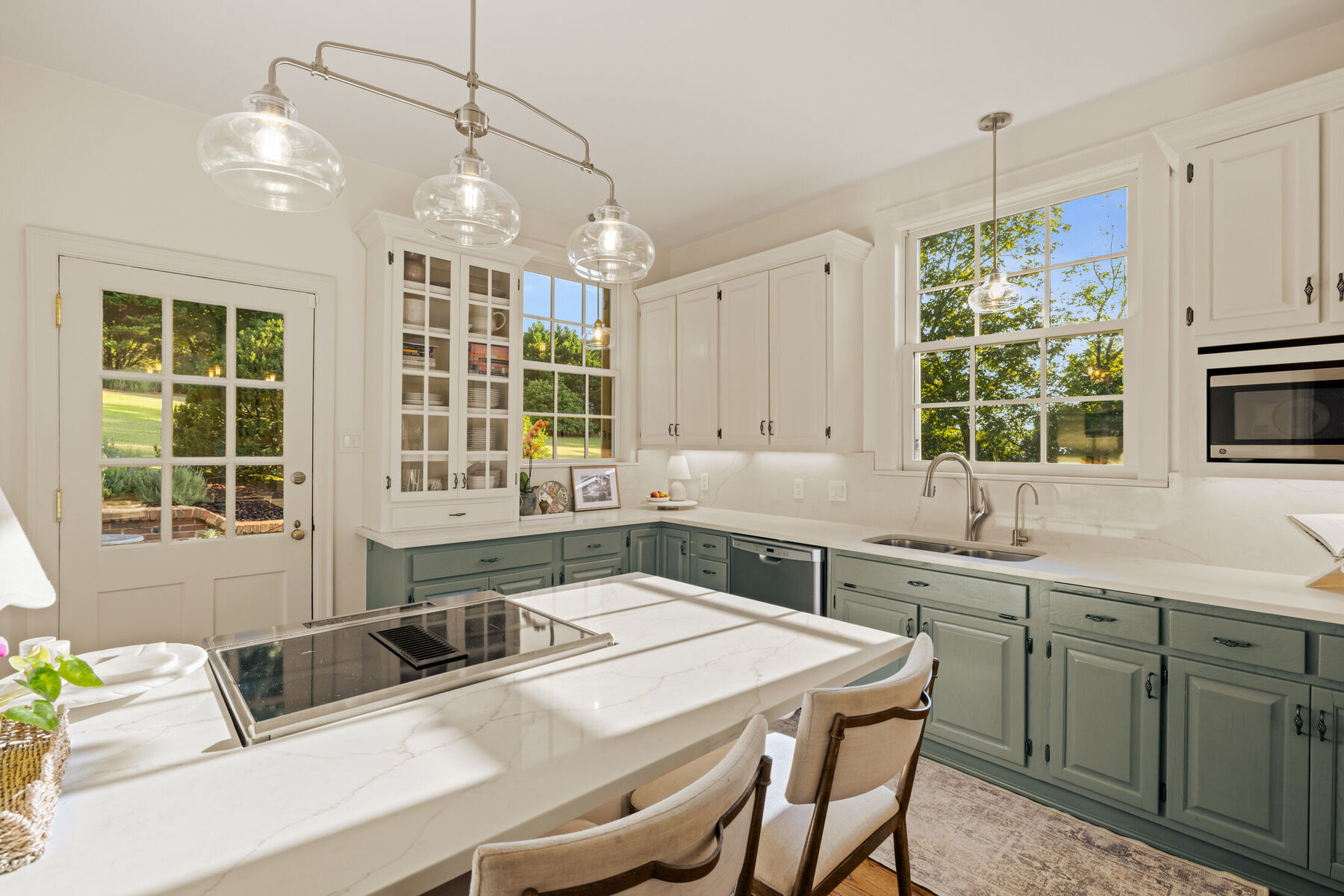 Bright kitchen with green lower cabinetry